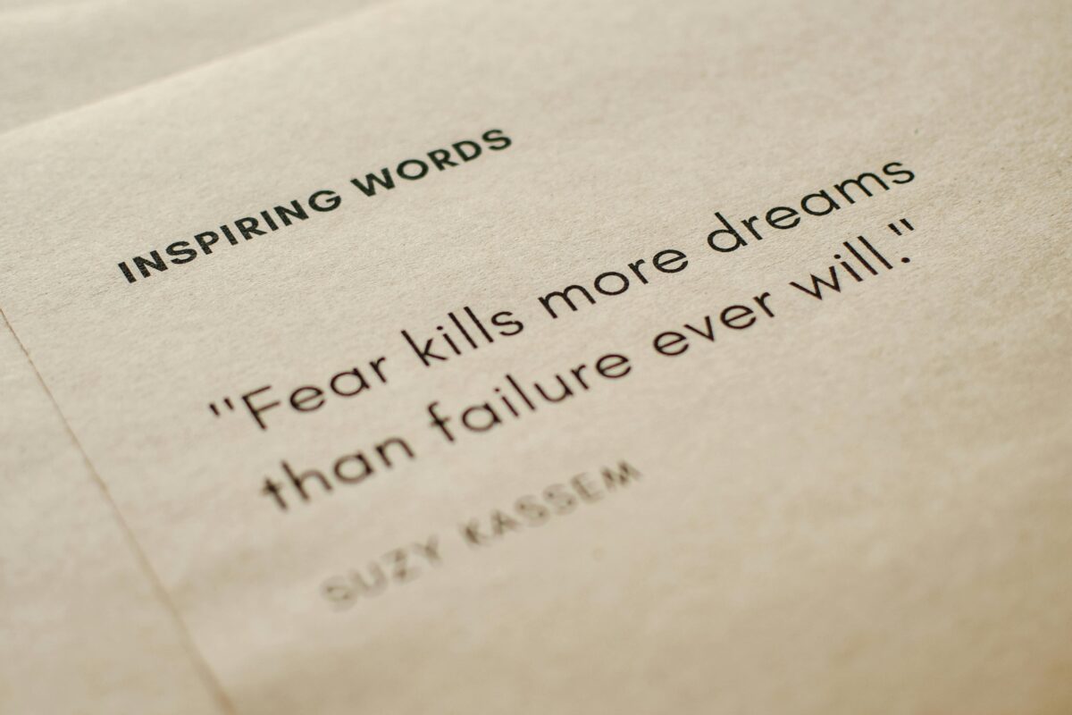 Motivational quote on brown paper emphasizing overcoming fear.